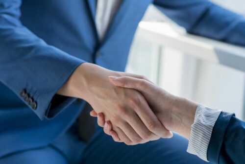 two-business-partners-shaking-hands-office